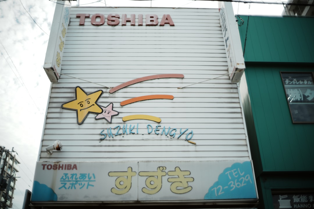 Old toshiba sign with cartoon stars and japanese text.