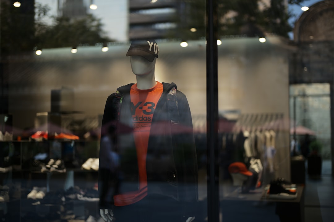 Mannequin in store window wearing orange shirt and jacket