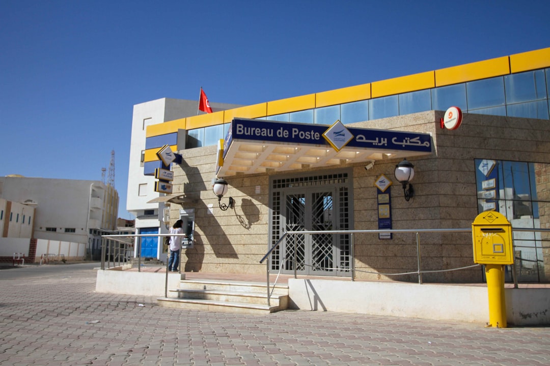A modern post office building with yellow accents.