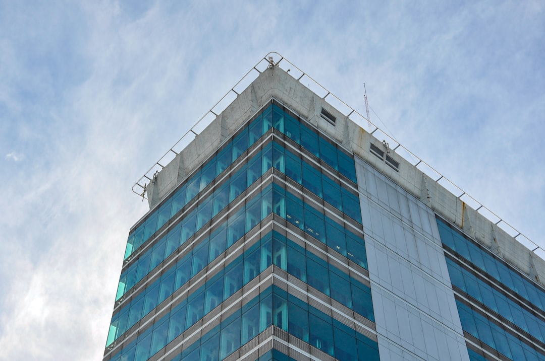Modern glass building against a cloudy sky