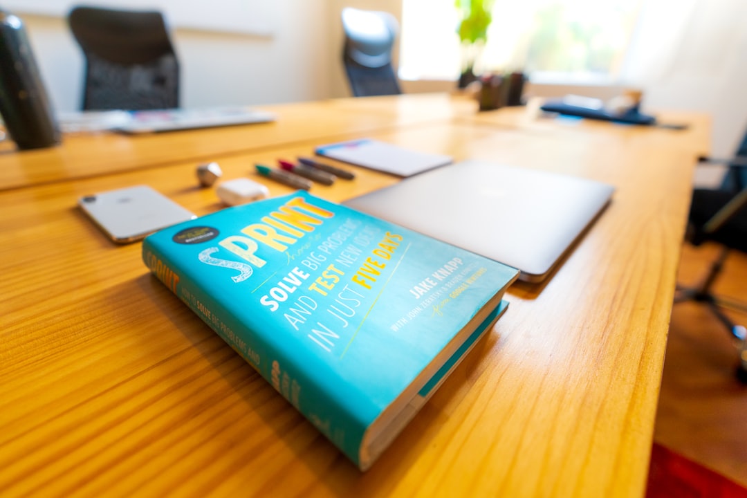 blue and green book on brown wooden table